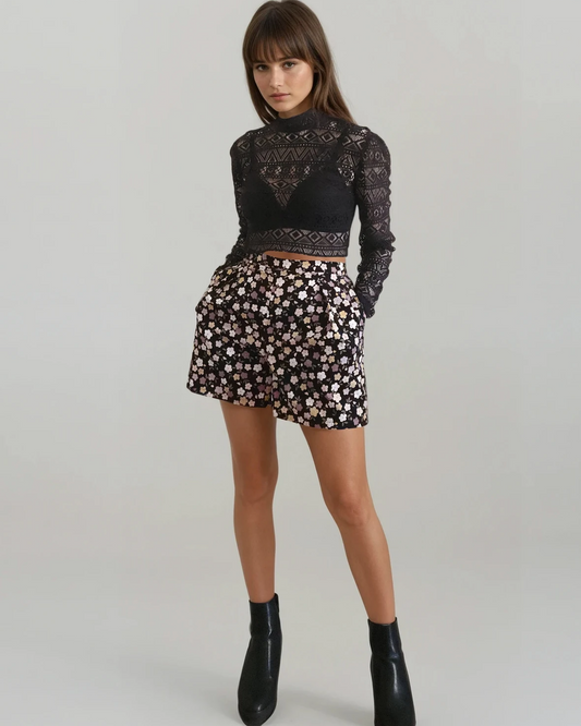 Woman wearing a black lace top and floral short