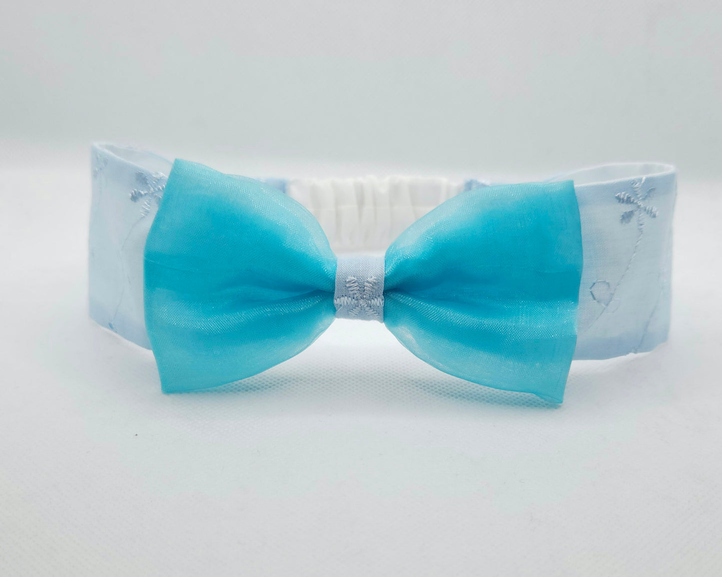 Baby blue bow headband on a white background