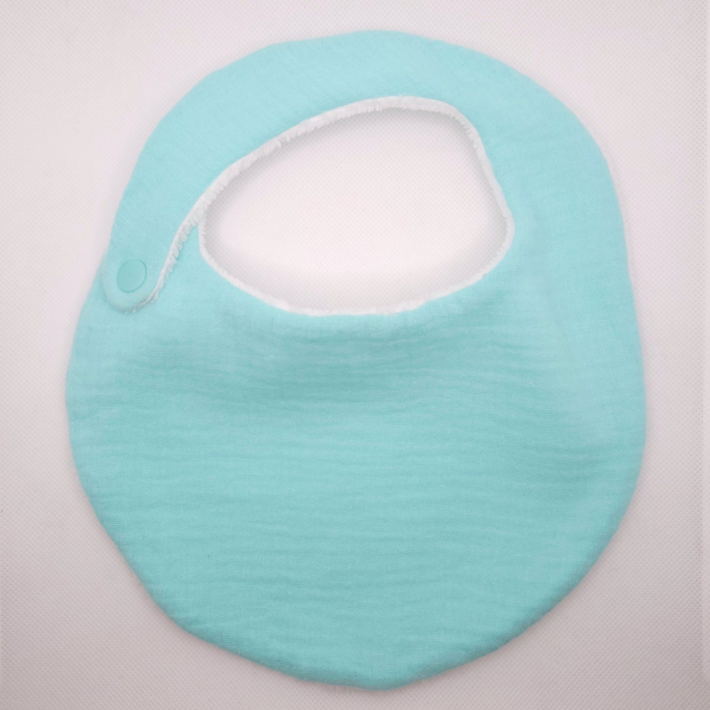 Light blue baby bib on a light gray background