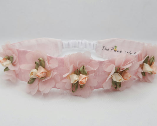 Pink floral headband on a white background