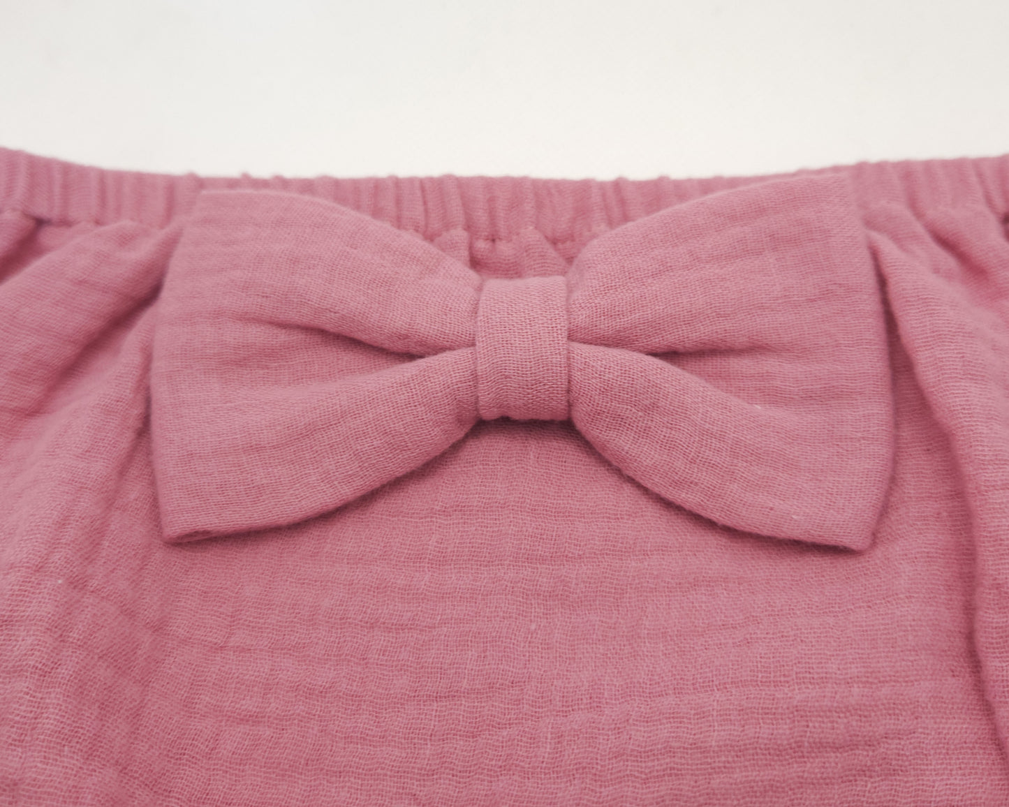 close up look at the cotton gauze  bow on the nappy cover