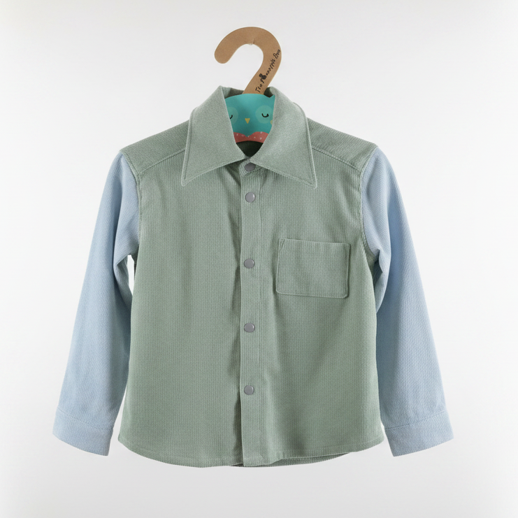 children's long-sleeve button-up shirt in sage green corduroy with light blue sleeves, hanging on a wooden hanger against a white background.