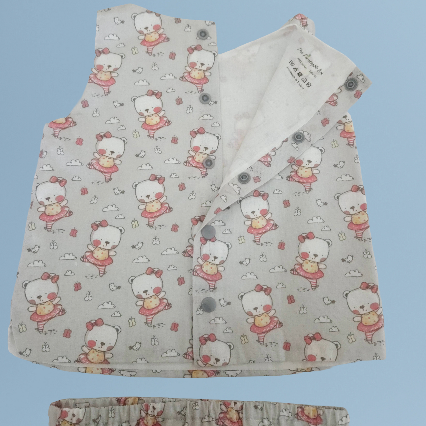 Baby back top with cartoon character pattern on a light blue background