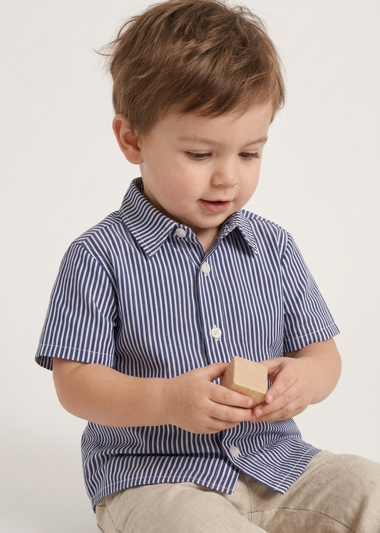Child wearing a blue striped shirt and beige pants holding wooden blocks on a white background