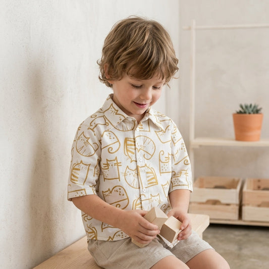 Child sitting on a wooden bench with the cat shirt 